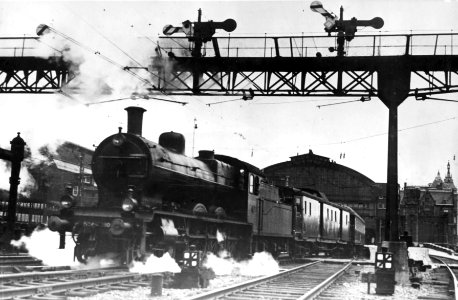 HUA-151282-Afbeelding van een stoomlocomotief uit de serie 3700 3800 van de NS met de internationale trein Edelweiss onder de seinbrug van het station Amsterdam 