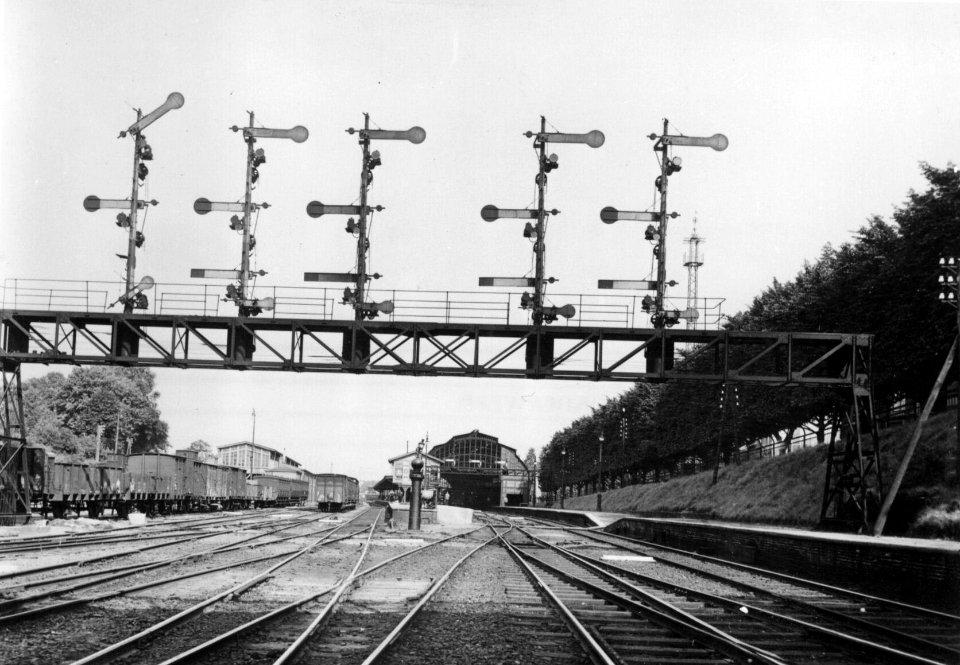 HUA-155272-Gezicht op de seinbrug te Arnhem vanuit het westen met op de achtergrond het station Arnhem van de Staatsspoorwegen