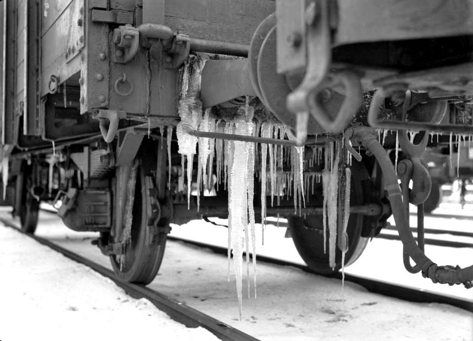HUA-159853-Afbeelding van ijspegels aan de buffer van een goederenwagen op het besneeuwde emplacement van de N.S. te Heerlen