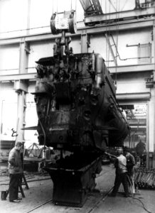 HUA-160586-Afbeelding van personeel van de Centrale Werkplaats van de NS te Tilburg aan het werk bij een in de takels gehangen ketel met vuurkist van een stoomlo