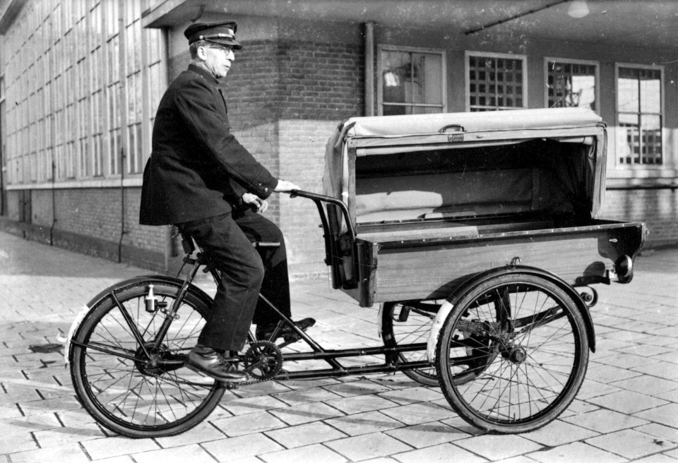 HUA-160631-Afbeelding van een beambte van de P.T.T. met een postfiets bij het Stationspostkantoor (Laan van Puntenburg 5) te Utrecht