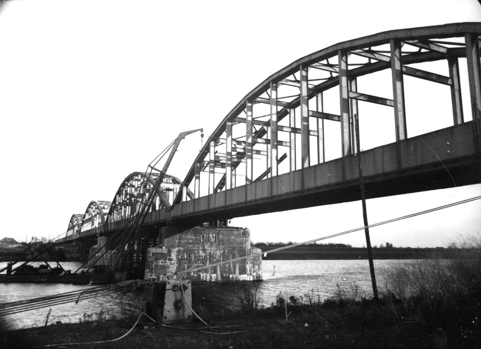 HUA-160682-Gezicht op de in herstelling zijnde spoorbrug over de Maas bij Ravenstein
