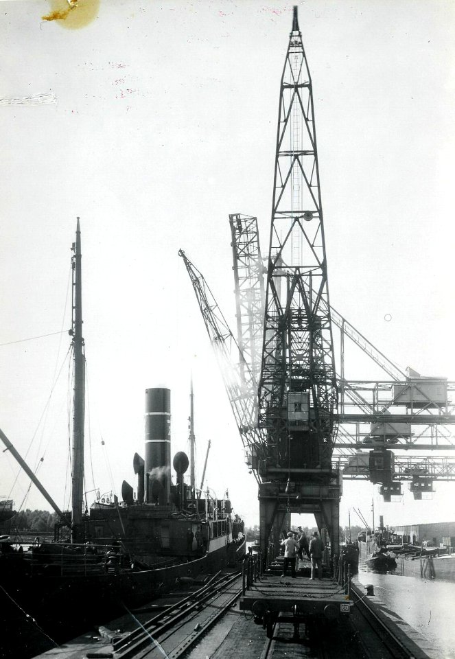 HUA-163190-Afbeelding van het lossen van spoorstaven met behulp van een havenkraan in de Zeehaven te Dordrecht