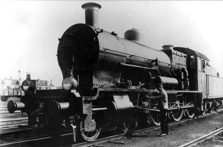 HUA-151478-Afbeelding van de stoomlocomotief nr. 3748 (serie 3700-3800) van de N.S. op een emplacement, met locpersoneel dat het drijfwerk van de locomotief smeert
