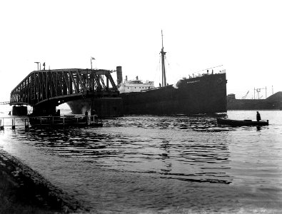 HUA-163222-Gezicht op de geopende spoorbrug over het Noordzeekanaal bij Velsen met het stoomschip Maasland 