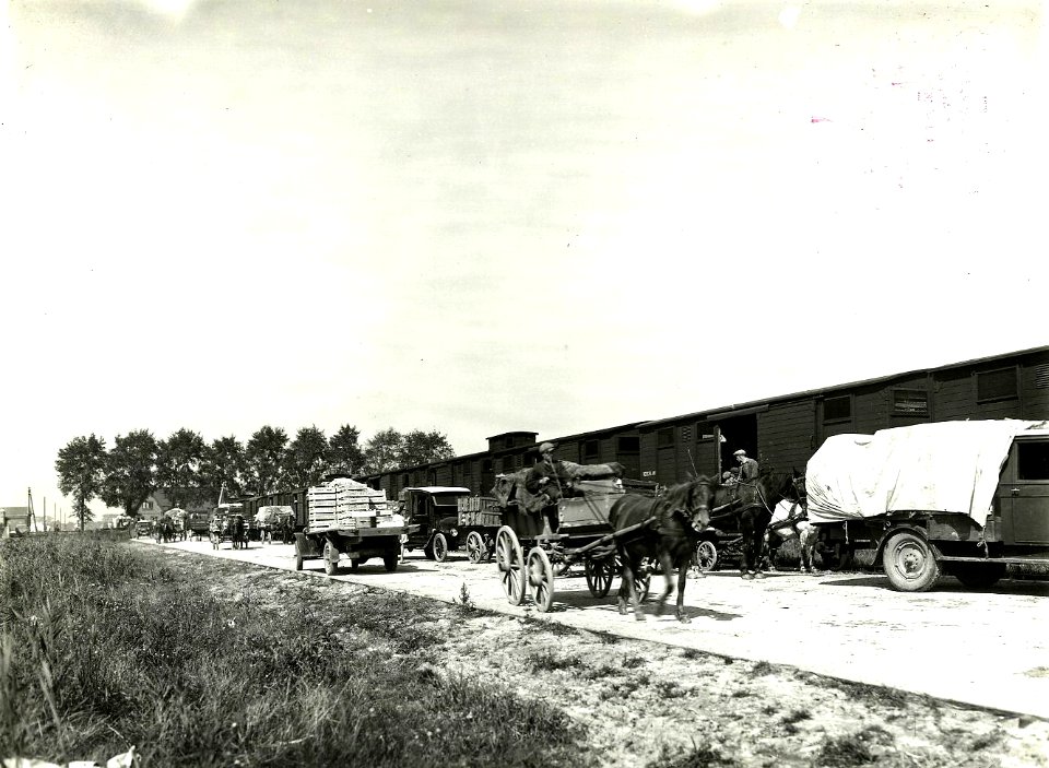 HUA-163230-Afbeelding van het overladen van groente en fruit van paard en wagen en auto naar de trein groentewagens op een onbekende laad en losplaats