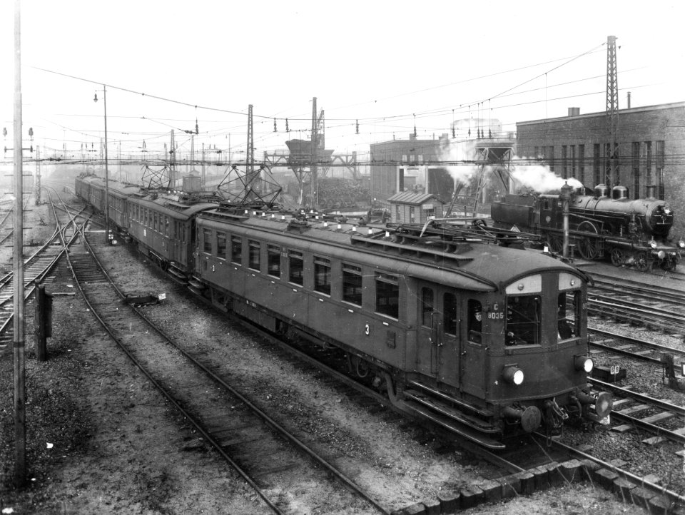 HUA-163248-Afbeelding van een trein bestaande uit rijtuigen electrisch buffermaterieel (blokkendozen, mat. 1924) van de N.S. met voorop het mototrijtuig nr. C 9035 te Amsterdam