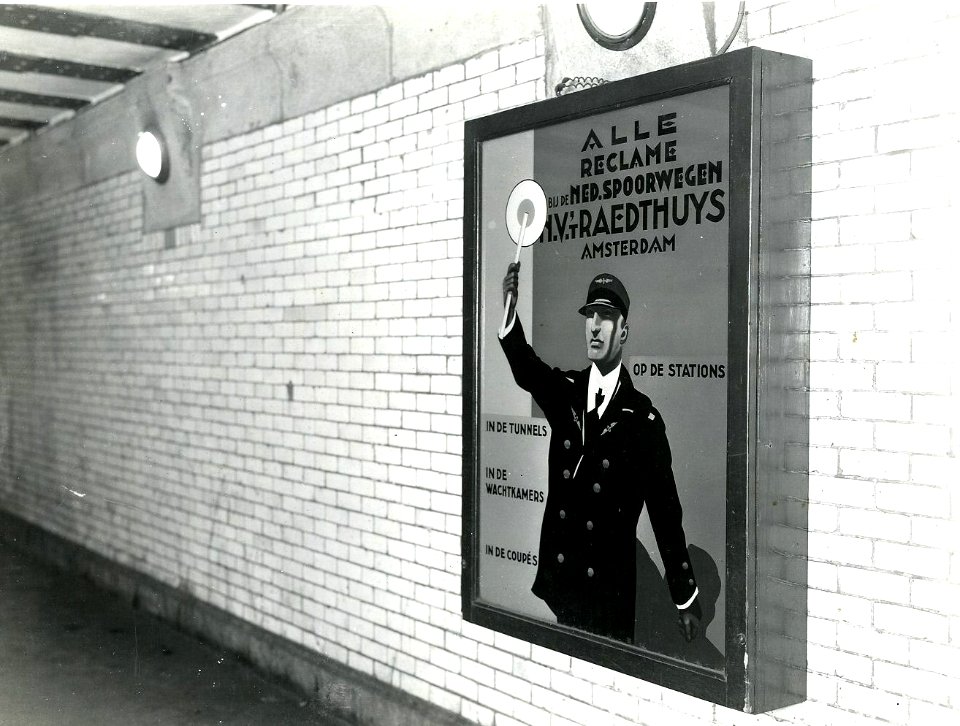 HUA-163266-Afbeelding van een lichtbak met reclame-affiche van N.V. 't Raedthuys te Amsterdam, vermoedelijk in de perrontunnel van het N.S.-station Amsterdam C.S. te Amsterdam