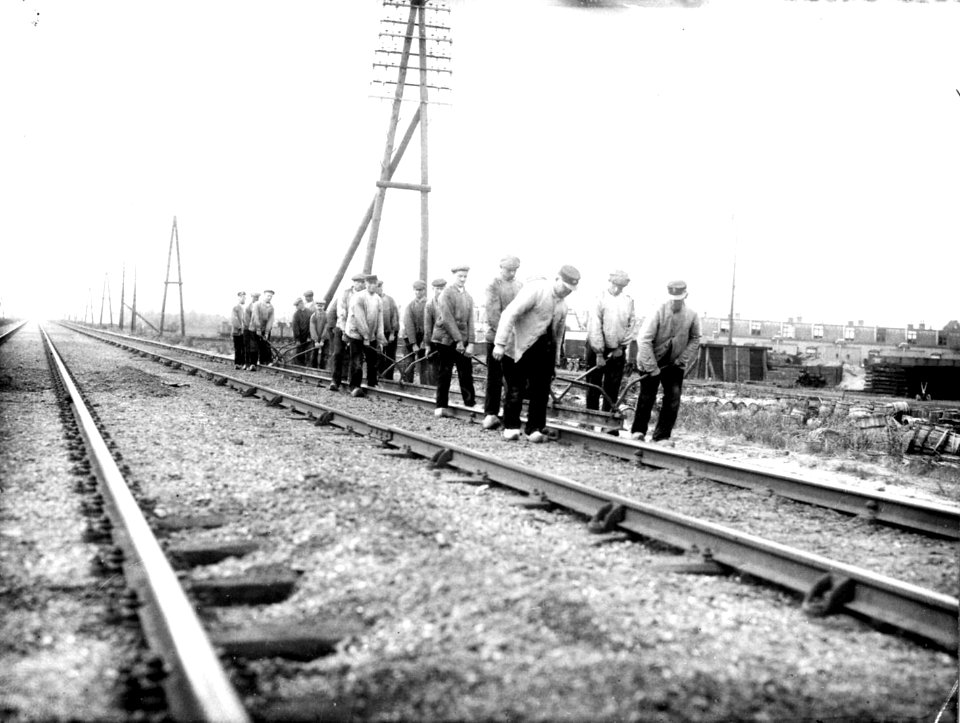 HUA-163302-Afbeelding van wegwerkers van de S.S. (Staatsspoorwegen) tijdens het wisselen van spoorstaven langs een onbekende spoorlijn