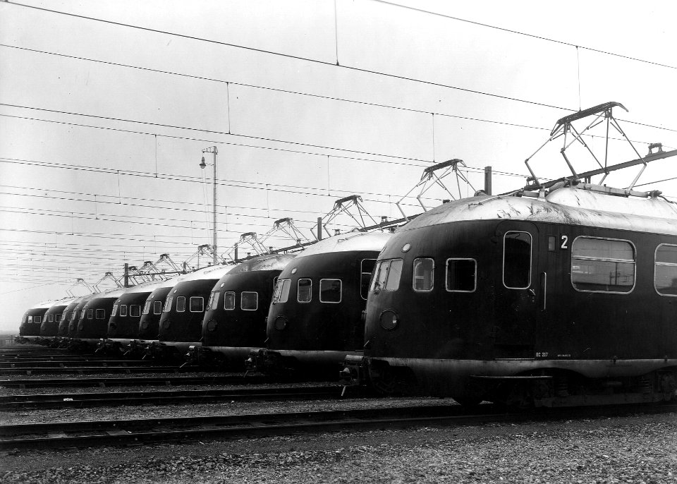HUA-163315-Afbeelding van een 'line-up' van 11 electrische treinstellen mat. 1936 van de N.S., gereed voor hun werk op het middennet, op het emplacement van de werkplaats van de N.S. te Leidschendam