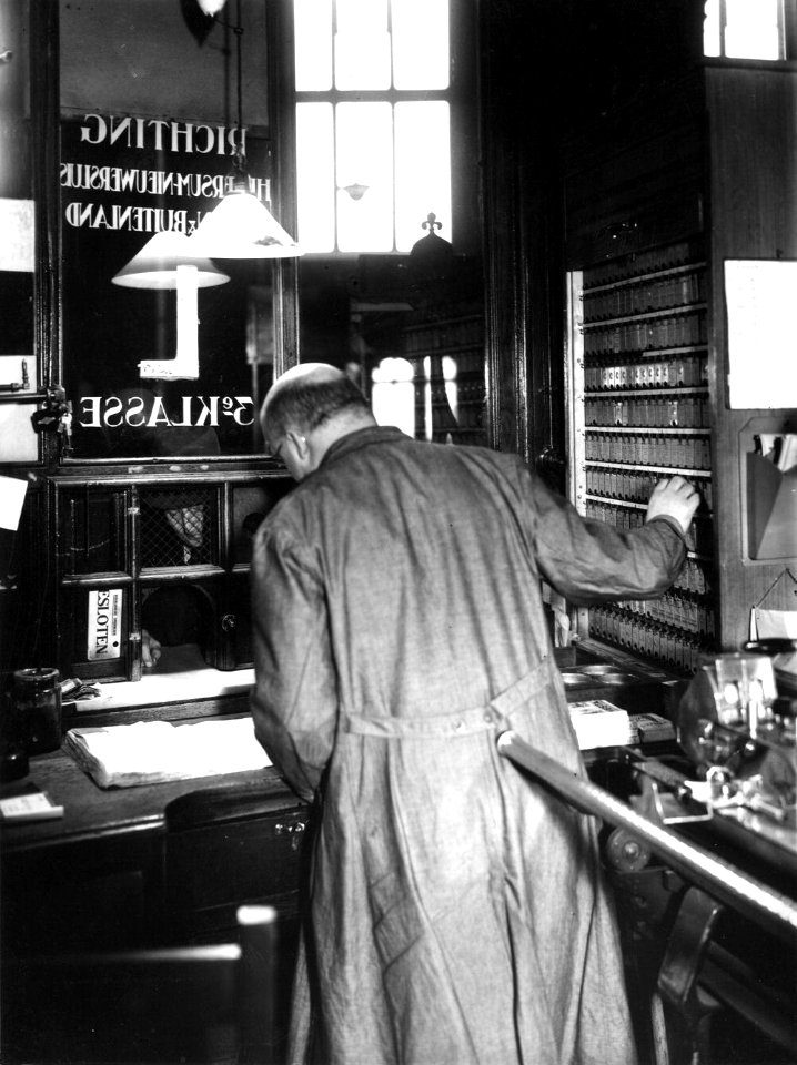HUA-163325-Interieur van het N.S.-station Amsterdam C.S. te Amsterdam- loket in het orgel (plaatskaartenkantoor) in de hal van het station, met lokettist