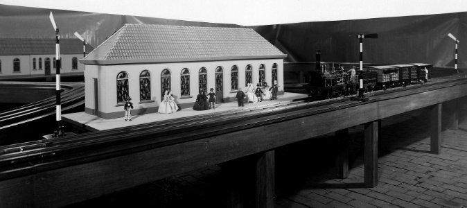 HUA-163400-Afbeelding van een spoorwegmodelbaan met een model van de stoomlocomotief De Arend van de H.S.M. met rijtuigen en twee modellen van het station Amsterdam d'Eenhonderd Roe. N.B. Deze modelbaan werd op 