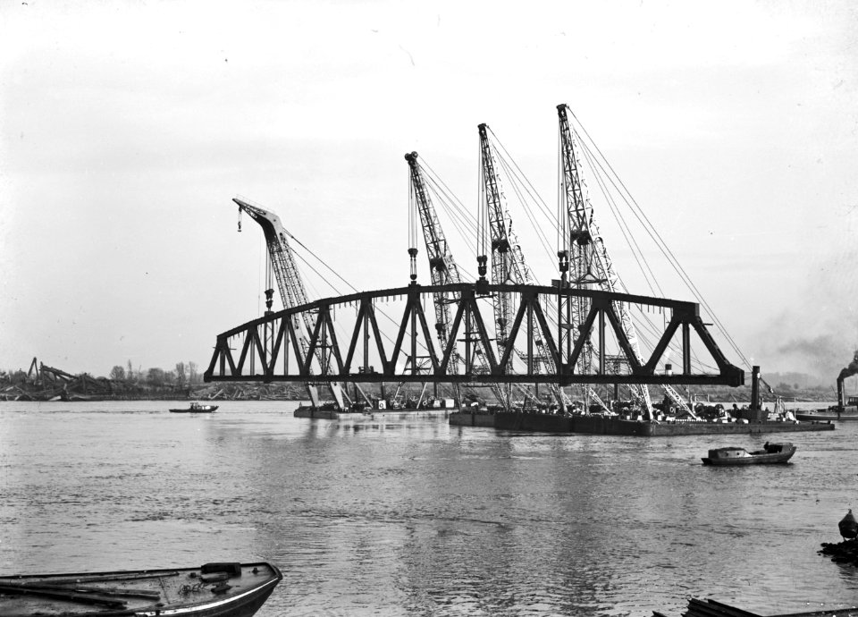 HUA-152725-Afbeelding van het invaren van een van de hoofdliggers van de middenoverspanning van de spoorbrug over de Waal bij Zaltbommel