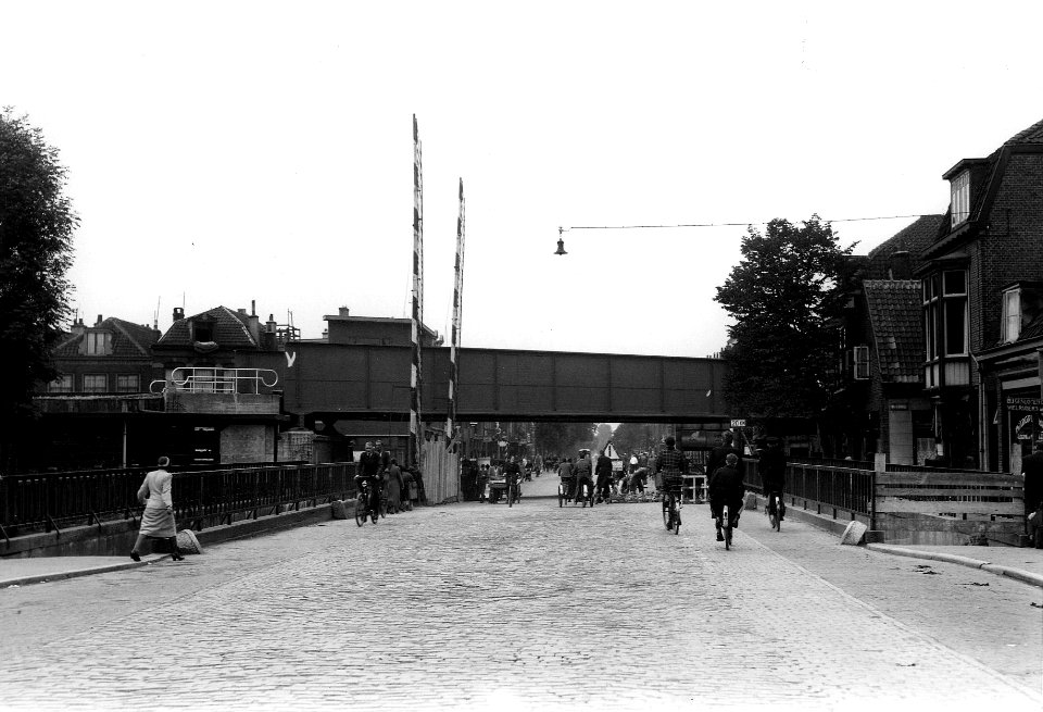 HUA-163629-Gezicht op het spoorviaduct over de Amsterdamsestraatweg te Utrecht, met daarvoor nog de overwegbomen van de oude overweg en de toegangen tot de voetgangerstunnels