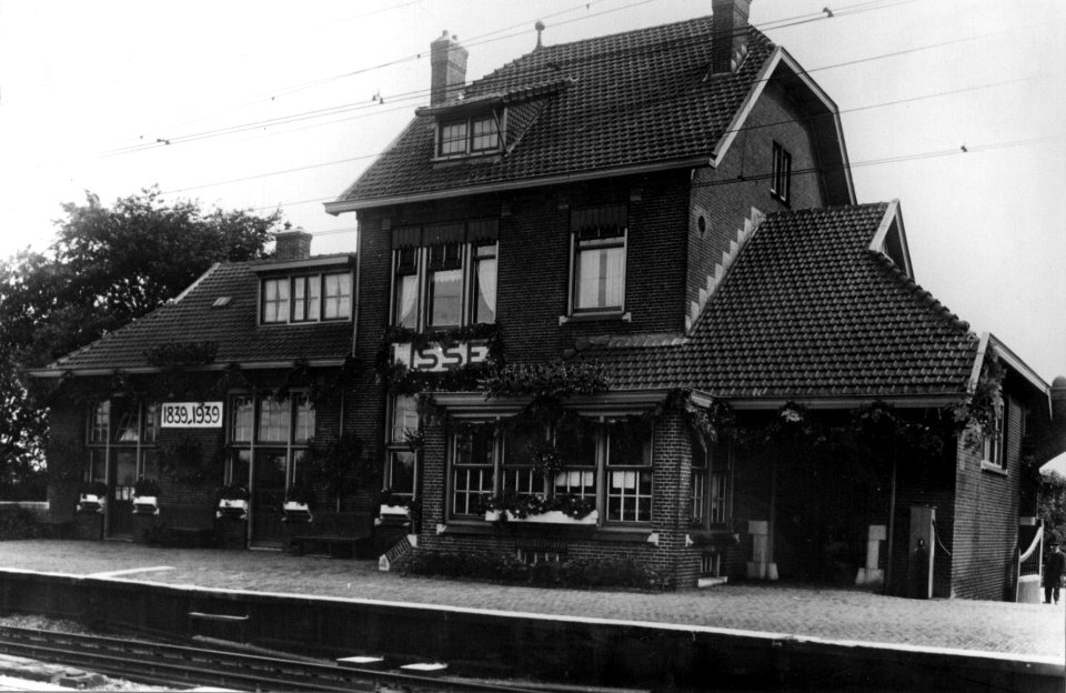 HUA-153803-Gezicht op een versierde N.S-station Lisse te Lisse gelegenheid van het 100-jarig bestaan van de N.S.