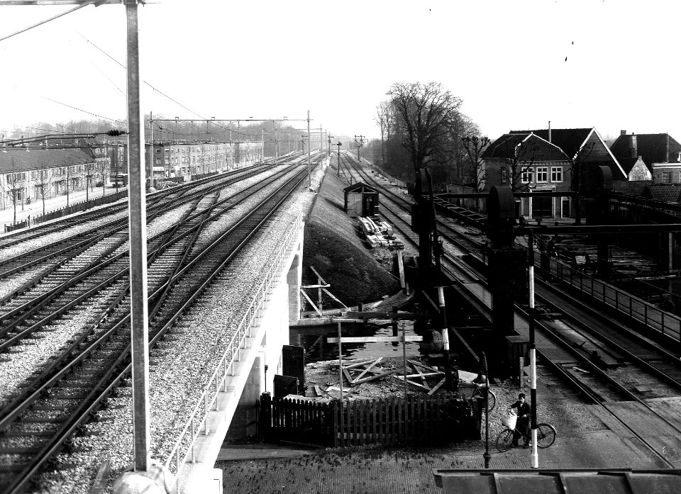 HUA-163701-Gezicht op de verhoogde spoorbaan te Utrecht met op de voorgrond de nieuwe spoorbrug over de Westerkade en de Vaartsche Rijn en rechts de tijdelijke h
