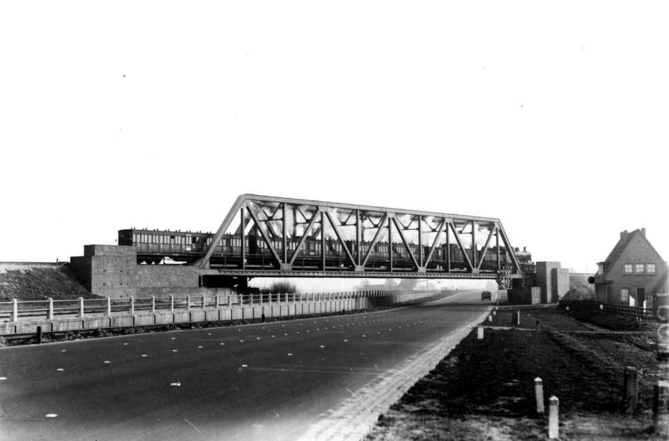 HUA-160480-Gezicht op het spoorviaduct over de Muiderstraatweg te Diemen met een passerende stoomtrein
