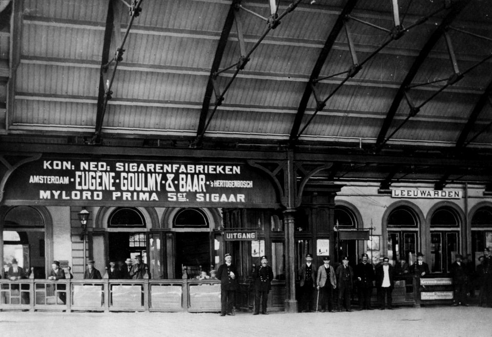 HUA-154635-Gezicht op het perron en de perronkap van het station Leeuwardenvan de Staatsspoorwegen te Leeuwarden met enkele personeelsleden