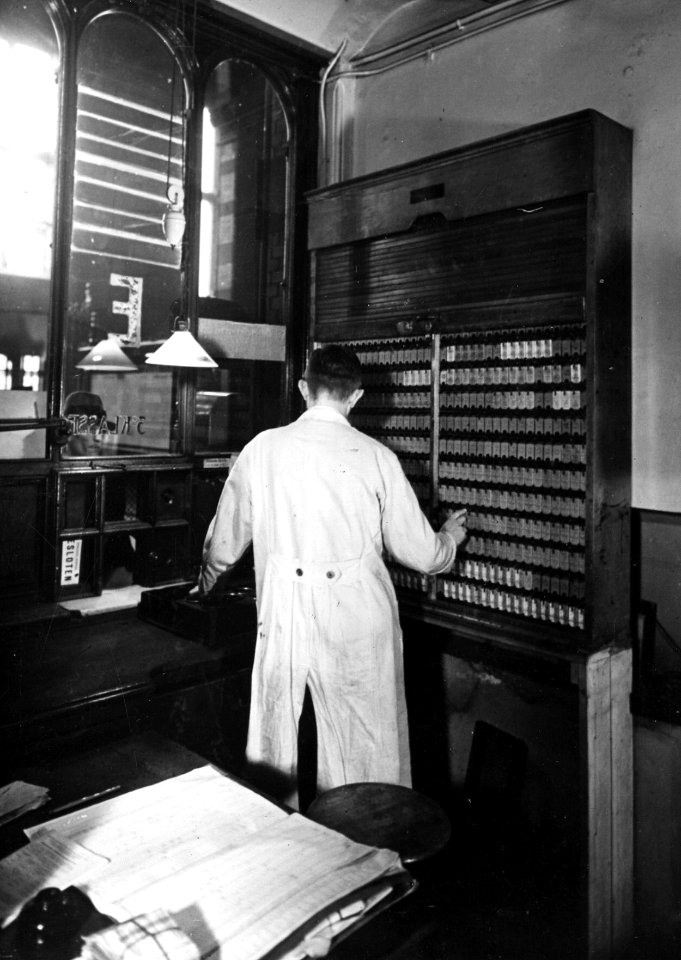HUA-165642-Interieur van het N.S.-station Amsterdam C.S. te Amsterdam- loket in het orgel (plaatskaartenkantoor) in de hal van het station, met lokettist