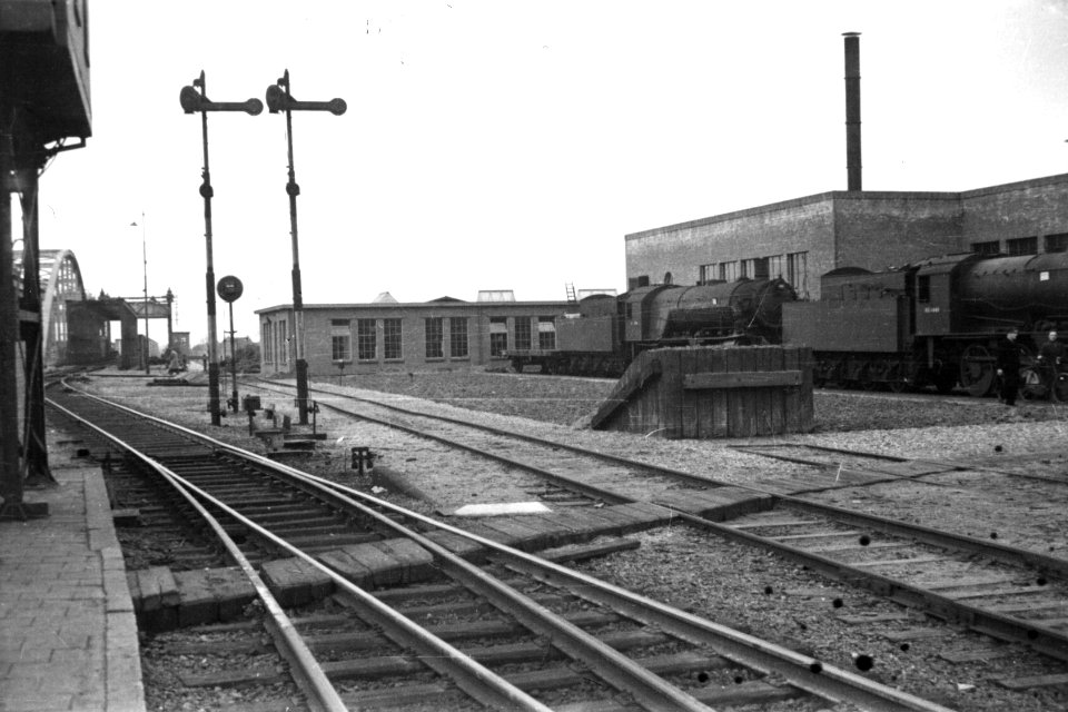 HUA-160585-Gezicht op een gedeelte van het tractieterein van de N.S. te Zutphen. Links de bruggen over de IJssel