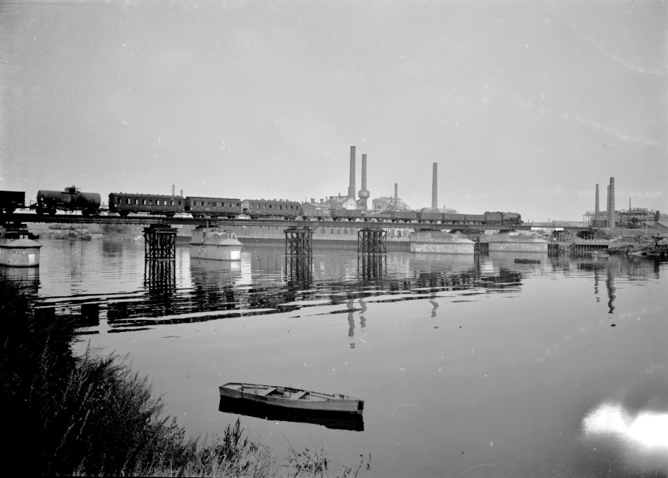 HUA-166643-Gezicht op de tijdelijk herstelde spoorbrug over de Maas te Maastricht, tijdens het passeren van een gemengde trein