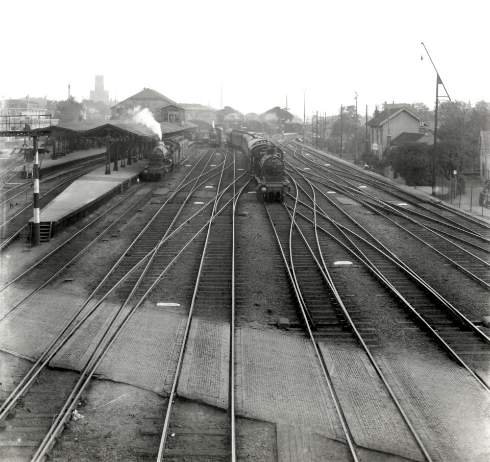 HUA-163244-Gezicht vanaf de voetgangersbrug in de Vleutenseweg op het emplacement aan de noordzijde van het N.S.-station Utrecht C.S. te Utrecht met enkele stoomtreinen. Links het Buurtstation