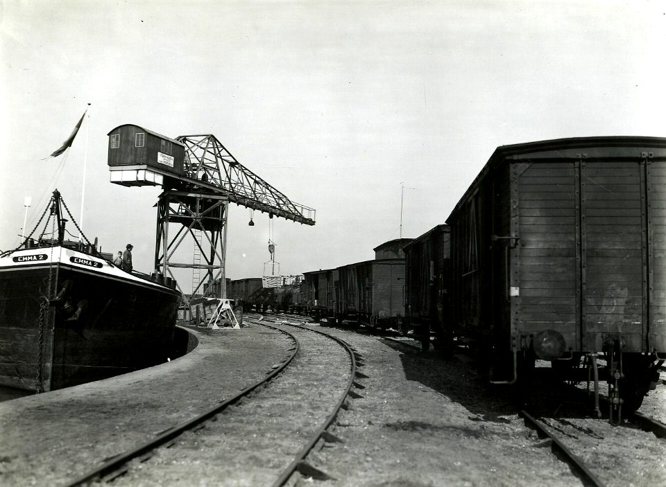 HUA-163263-Afbeelding van goederenwagens van de N.S. op de kade van de haven te Nijmegen, met links het schip Emma