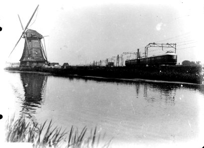 HUA-160496-Afbeelding van twee gekoppelde treinstellen mat. 1935 (Hoek van Hollanders) van de N.S. ter hoogte van een molen, vermoedelijk langs de spoorlijn tussen Schiedam en Hoek van Holland