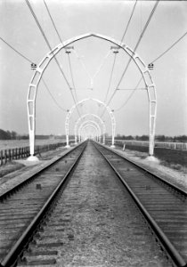 HUA-167147-Gezicht op de spoorlijn bij Maartensdijk, kort na de electrificatie, met de halfronde betonnen bovenleidingsportalen (driescharnierenboog-constructie)