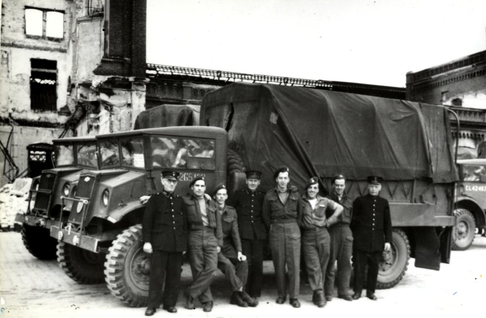 HUA-168058-Afbeelding van vrachtauto's van het Canadese leger die ingezet worden door de N.S. als vervangend vervoer voor treintreizigers op het Stationsplein te Arnhem, met enkele poserende soldaten (chauffeurs