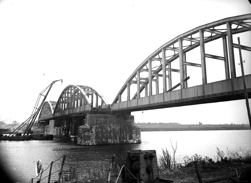 HUA-160681-Gezicht op de in herstelling zijnde spoorbrug over de Maas bij Ravenstein