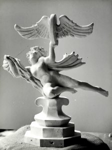 HUA-168126-Afbeelding van een beeldje van een engelfiguur puto met een gevleugeld wiel allegorie van de spoorwegen 