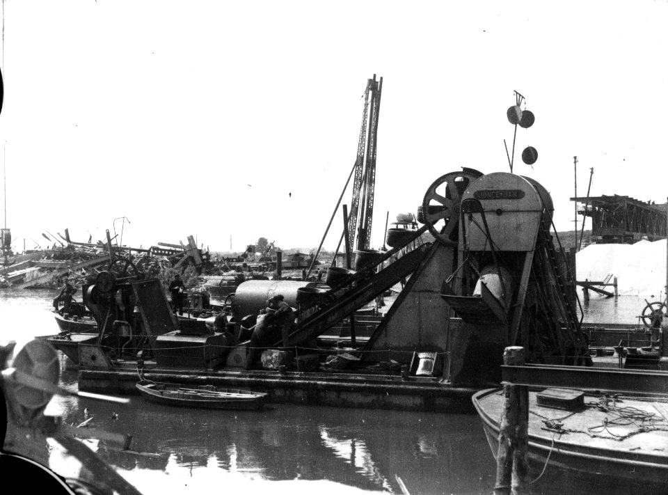 HUA-160685-Afbeelding van een baggerschuit bij de in herstelling zijnde spoorbrug over de IJssel bij Westervoort