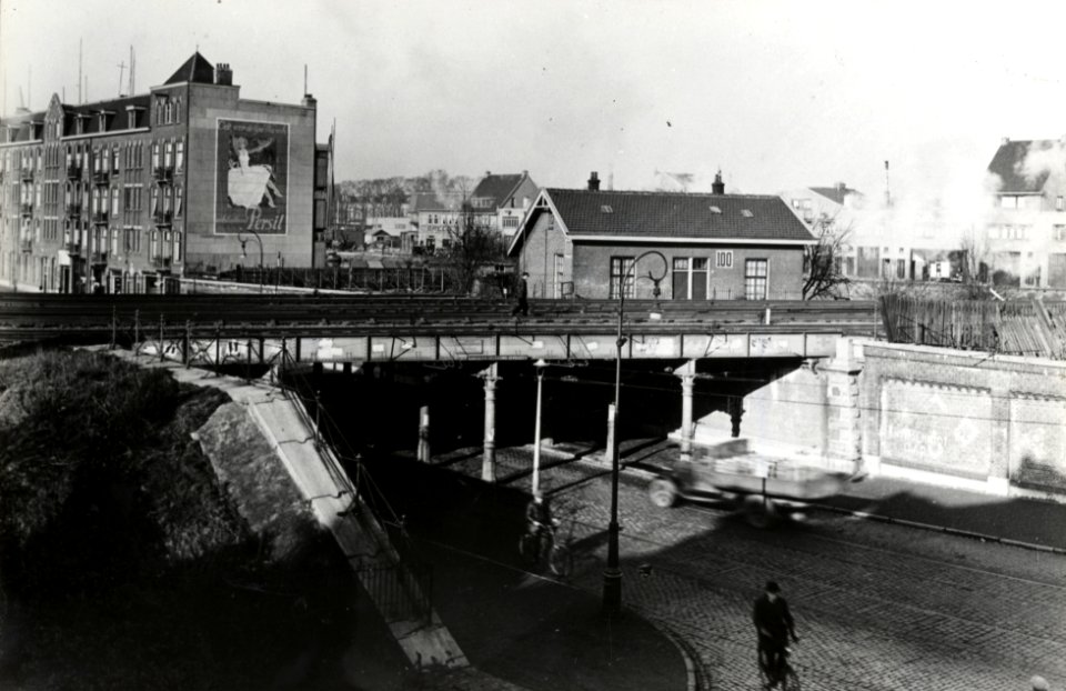 HUA-169102-Gezicht op het spoorviaduct over de Zeeburgerdijk te Amsterdam, met rechts wachtpost 100. N.B. De afbeelding maakt deel uit van een serie foto's met betrekking tot de Spoorwegwerken te Amsterdam