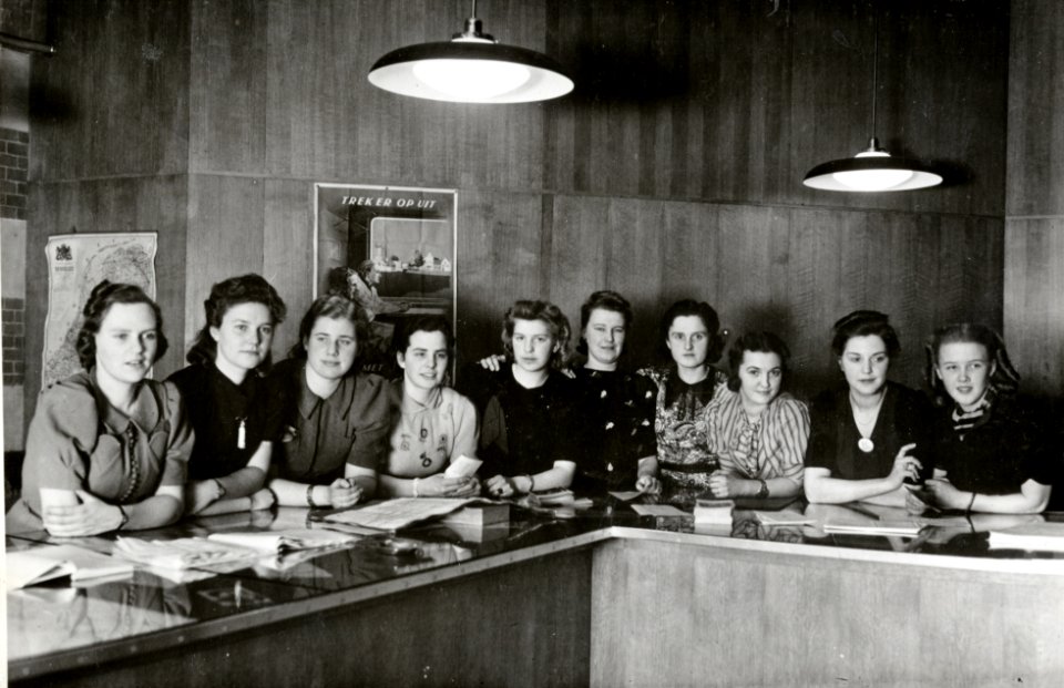 HUA-169283-Groepsportret van de informatrices van het inlichtingenbureau in het N.S.-station Amsterdam C.S. te Amsterdam