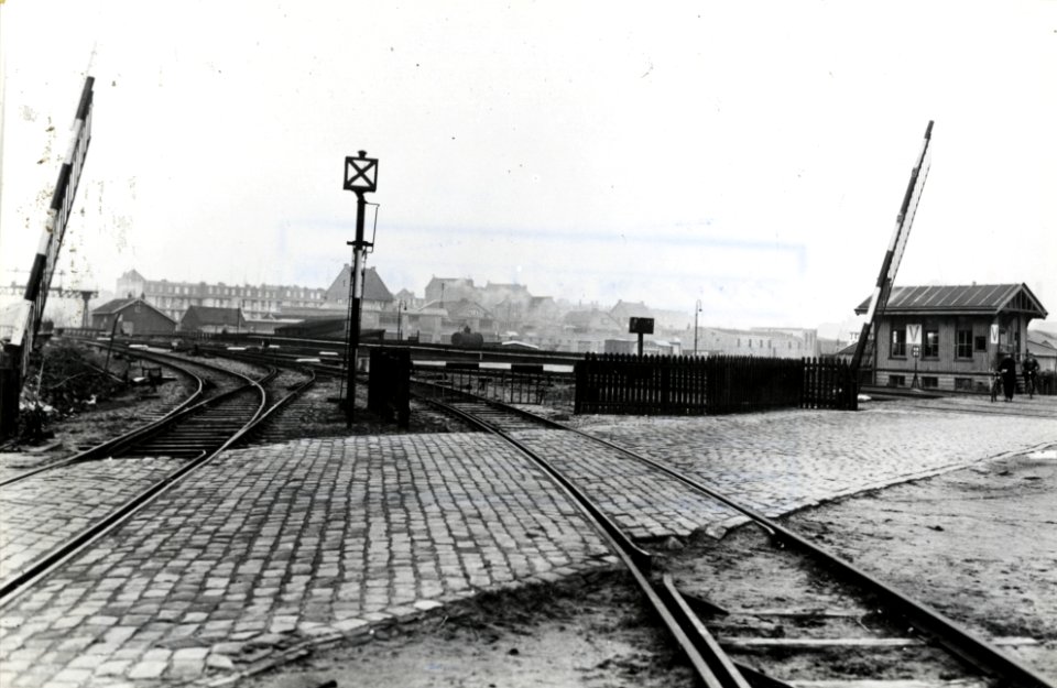 HUA-169354-Gezicht op het spoorwegovergang in de Cruquiusweg te Amsterdam, met rechts blokpost V. N.B. De afbeelding maakt deel uit van een serie foto's met betrekking tot de Spoorwegwerken te Amsterdam