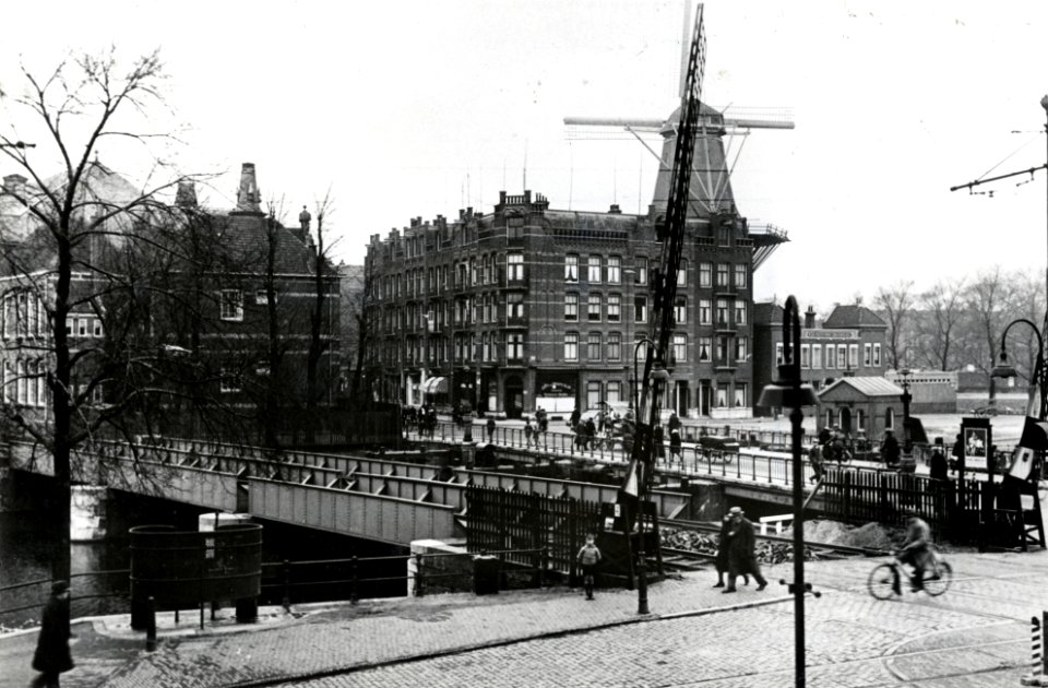 HUA-169360-Gezicht op de spoorbrug over de Singelgracht te Amsterdam voor de sporen naar het goederenstation aan de Doklaan, vanaf de spoorwegovergang in de Mauritskade (rechts op de voorgrond). Rechts op de ach