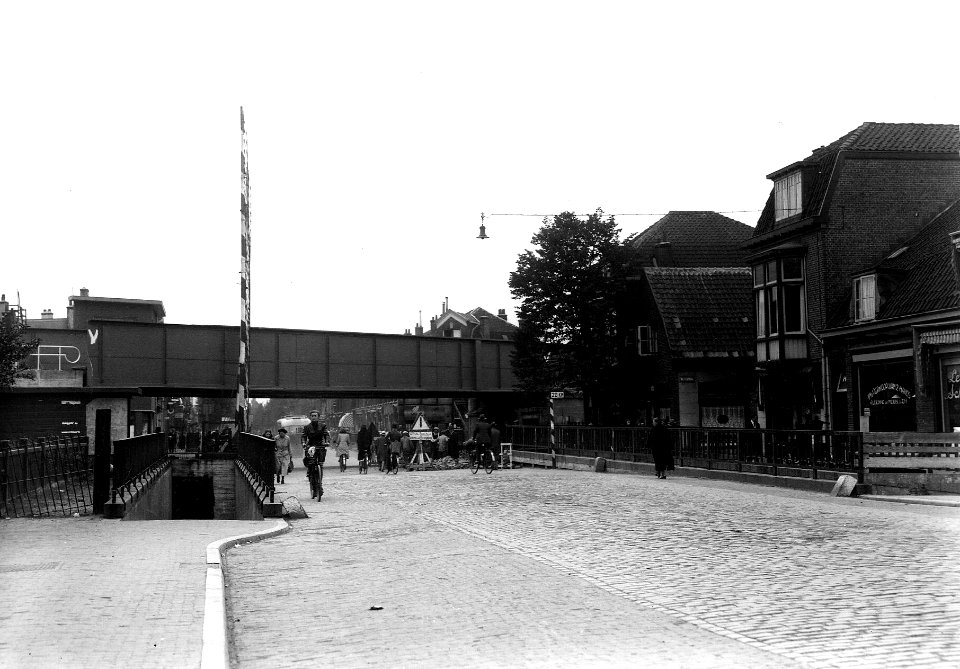 HUA-163630-Gezicht op het spoorviaduct over de Amsterdamsestraatweg te Utrecht, met daarvoor nog de overwegbomen van de oude overweg en de toegangen tot de voetgangerstunnels