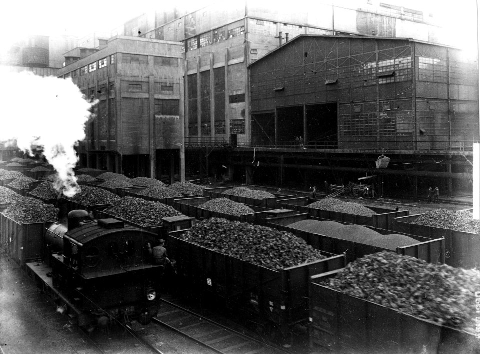 HUA-163336-Gezicht op de cokesfabriek van de Staatsmijn Maurits te Geleen met op de voorgrond het spoorwegemplacement met cokes beladen geoderenwagens en links d
