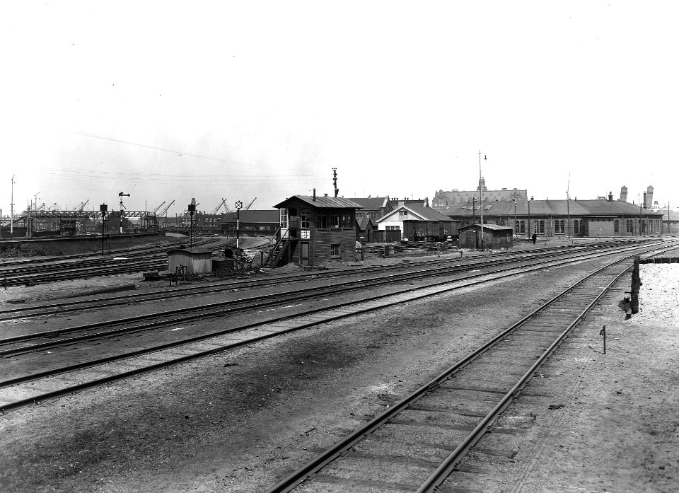 HUA-163655-Gezicht op het seinhuis Post 3 op het goederenemplacement Rietlanden te Amsterdam, met rechts op de achtergrond de ronde locomotiefloods. N.B. De afbeelding maakt deel uit van een serie foto's met bet