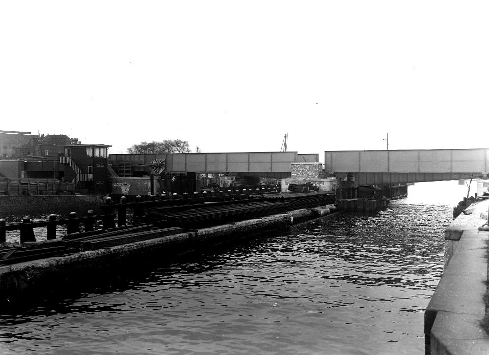 HUA-163676-Gezicht op de spoorbrug over de Oosterdoksluis te Amsterdam. N.B. De afbeelding maakt deel uit van een serie foto's met betrekking tot de Spoorwegwerken te Amsterdam