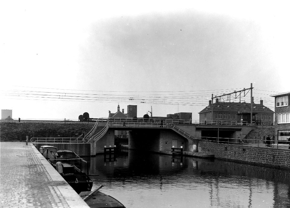 HUA-163700-Gezicht op de nieuwe spoorbrug over de Vaartsche Rijn te Utrecht, met rechts het viaduct over de Westerkade en op de achtergrond Post D. N.B. De afbeelding maakt deel uit van een serie foto's met betr