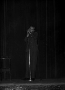 HUA-163574-Afbeelding van een muzikant met een mondharmonica tijdens een feestavond ter gelegenheid van de herdenking van de spoorwegstaking van 1944