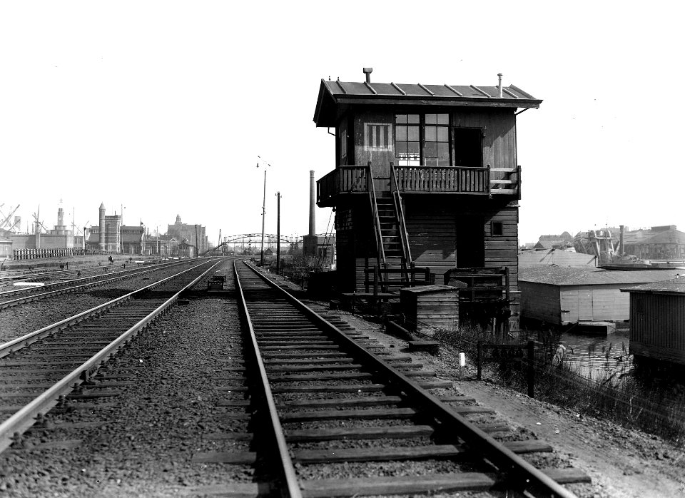 HUA-163645-Gezicht op het seinhuis Post III aan de Handelskade te Amsterdam, met geheel op de achtergrond het goederenemplacement Rietlanden. N.B. De afbeelding maakt deel uit van een serie foto's met betrekking
