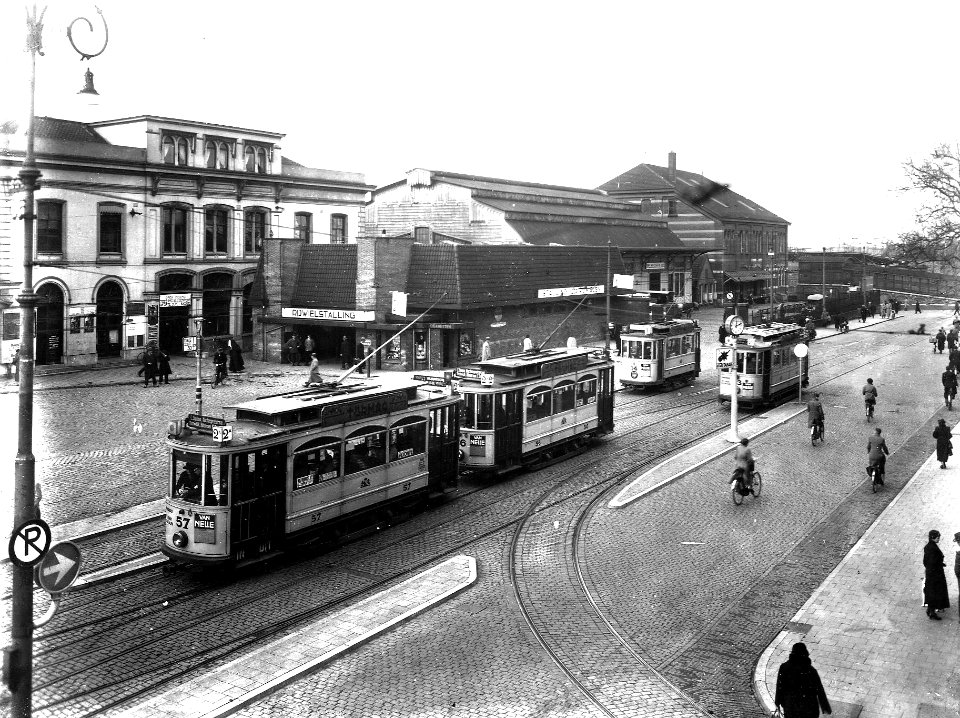HUA-163698-Gezicht op een gedeelte van het Stationsplein te Utrecht, met enkele electrische trams van het G.E.T.U. en op de achtergrond een deel van het N.S.-station Utrecht C.S. met de rijwielstalling en de sne