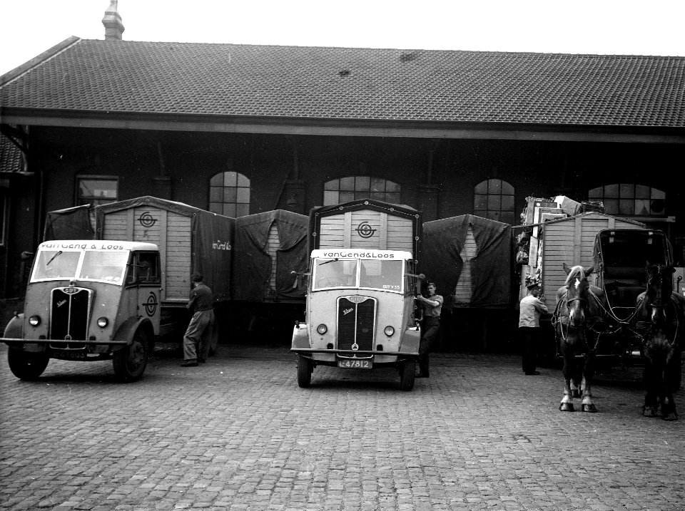 HUA-163740-Afbeelding van twee vrachtauto's en een met paarden bespannen wagen van Van Gend & Loos bij de goederenloods van de N.S. te Amersfoort, met enkele laadkisten van de A.T.O.-Van Gend & Loos van het syst