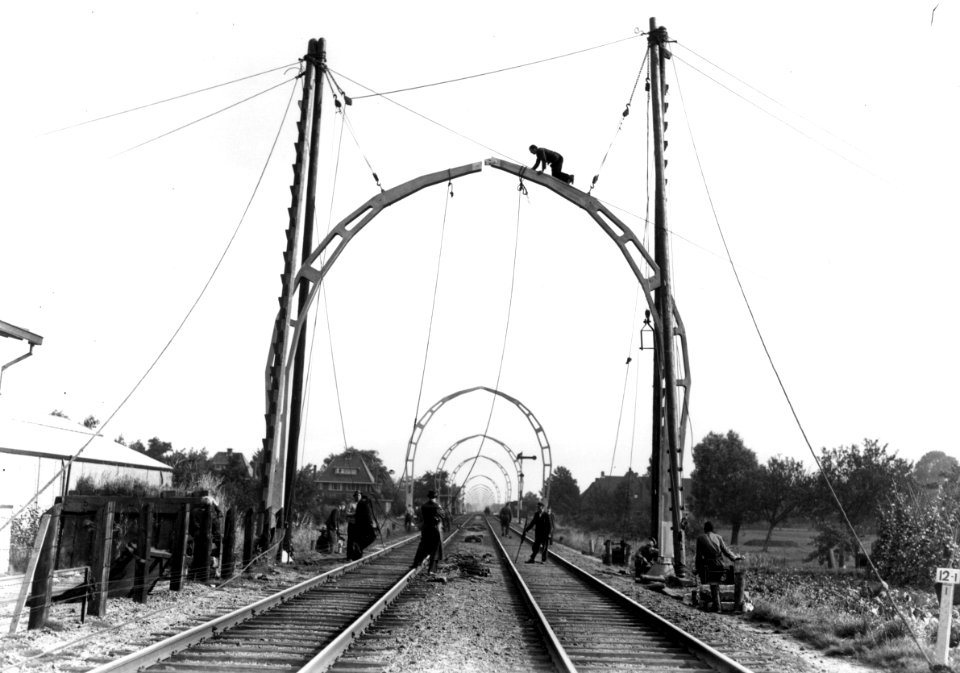 HUA-166404-Afbeelding van het stellen van een betonnen bovenleidingsportaal tijdens de werkzaamheden ten behoeve van de electrificatie van de spoorlijn tussen Ut