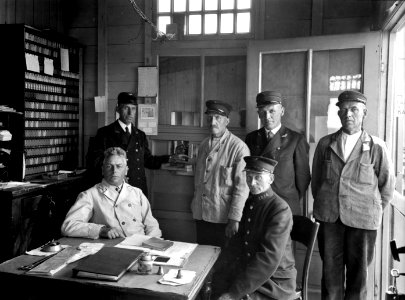 HUA-166025-Groepsportret van het personeel van het N.S.-station Lent te Lent. N.B. De halte Lent was gedurende de oorlogsjaren 1940-1941 van belang als overstapstation voor de pont over de Waal naar Nijmegen in 