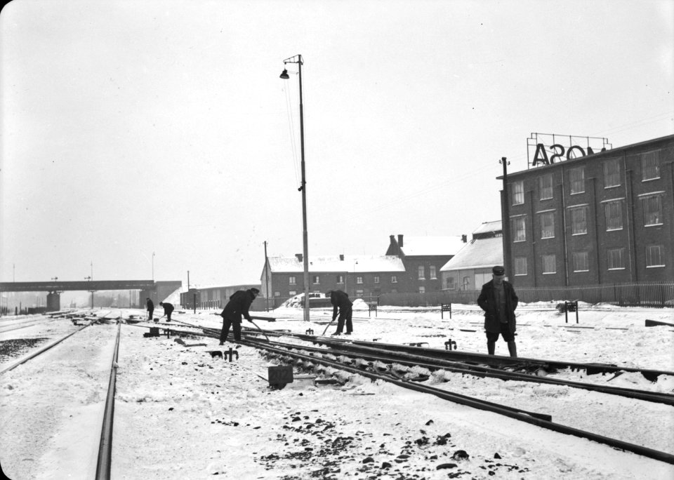 HUA-166030-Afbeelding van enkele wegwerkers van de N.S. die vastgevroren wissels op het emplacement te Maastricht trachten los te krijgen