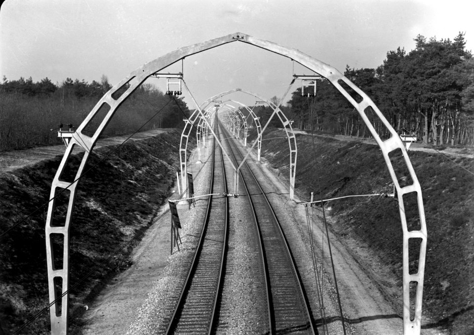 HUA-167143-Gezicht op de spoorlijn bij Hollandsche Rading, met halfronde betonnen bovenleidingsportalen (driescharnierenboog-constructie), kort na de electrificatie van de lijn